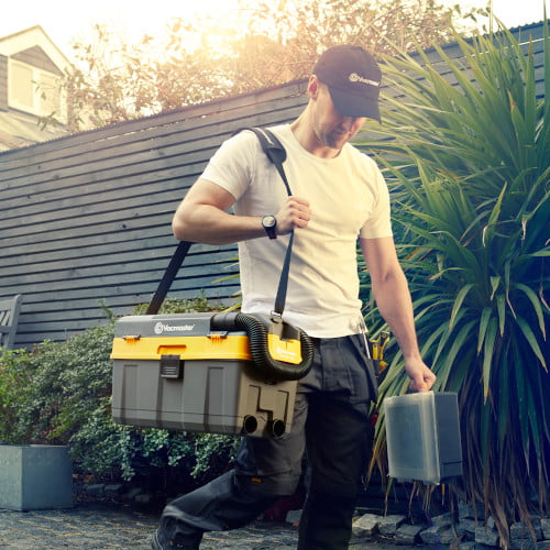 a tradesman carrying a cordless tollbax vacuum cleaner on his shoulder