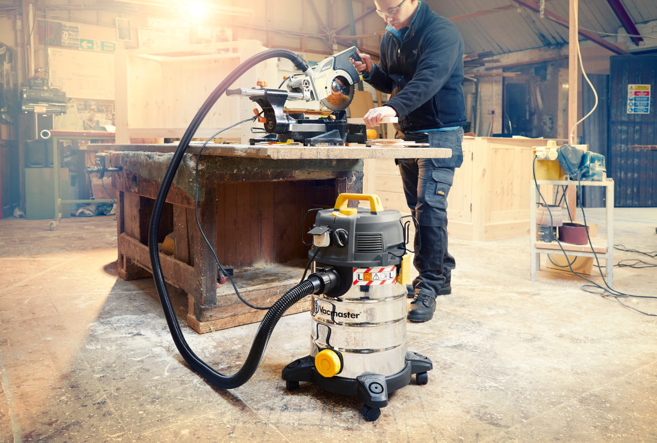 builder using saw and vacuum cleaner